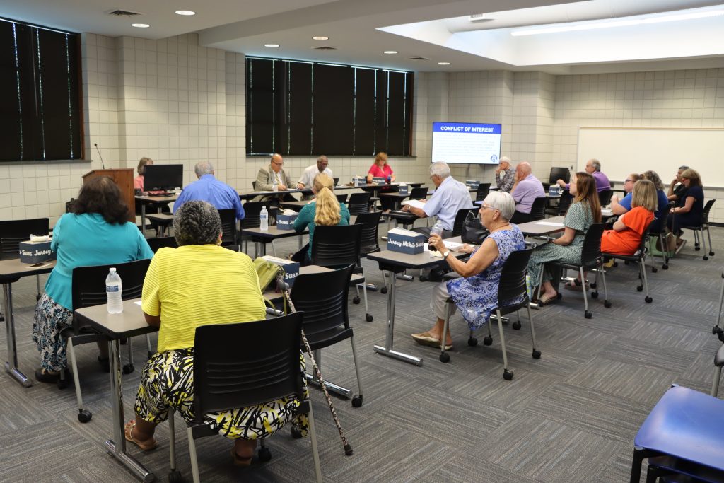 The SCC Board of Trustees and meeting attendees review information presented at Tuesday’s board meeting.
