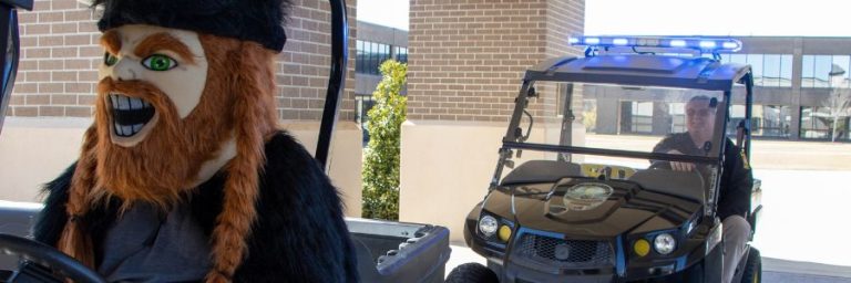 Viking mascot and security officer in golf carts