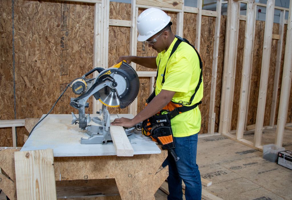 Student operating saw to cut lumber