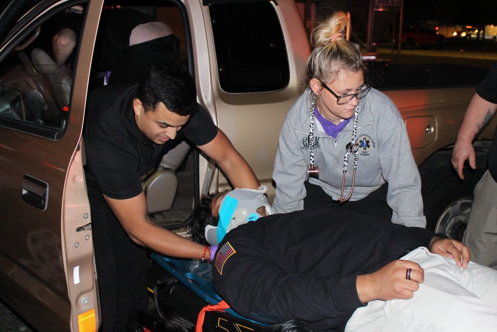 EMS personnel maneuvering person on a gurney.