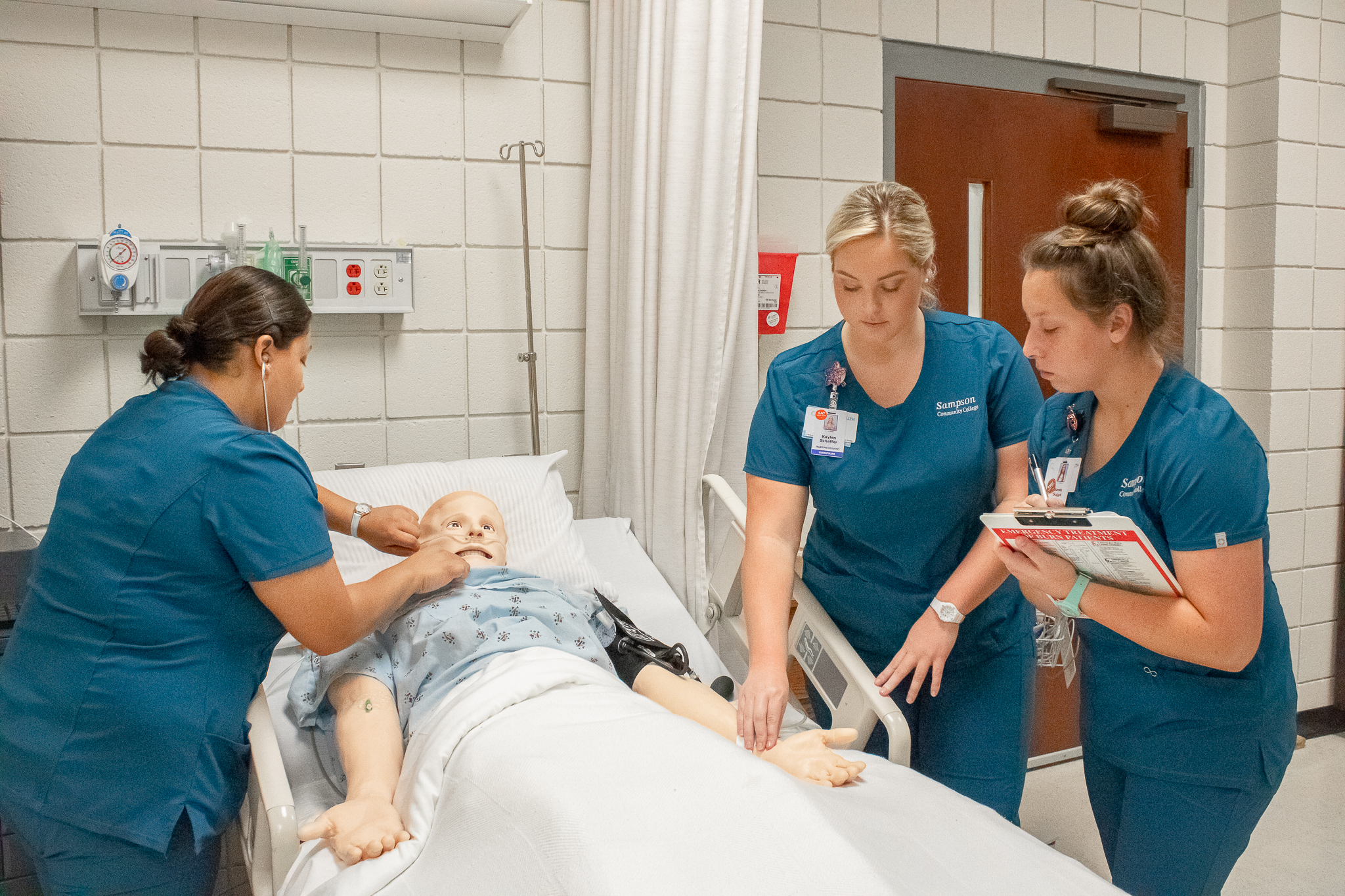 Nursing students practicing on a mannequin,