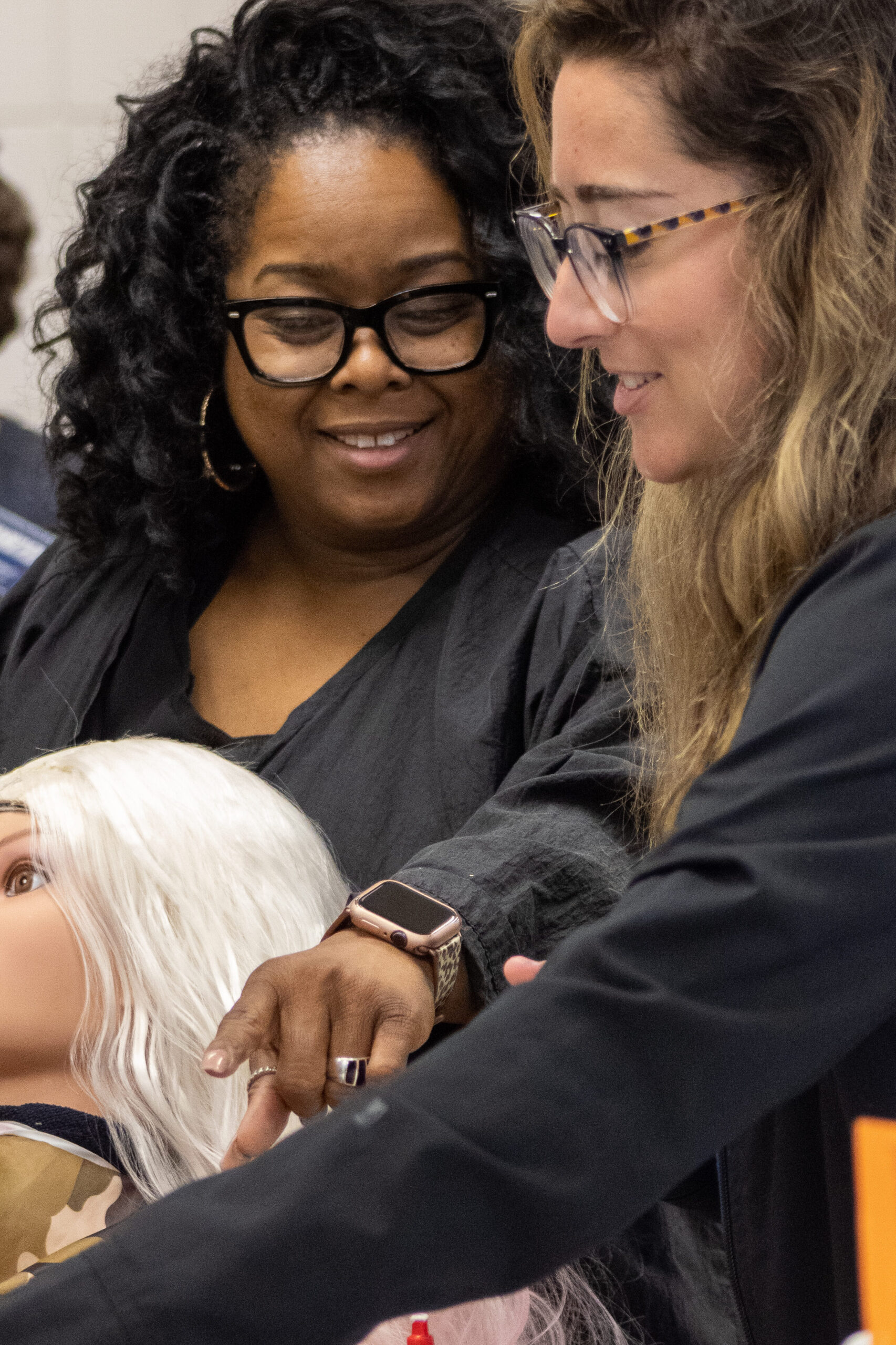 Photo of a cosmetology instructor helping a student.